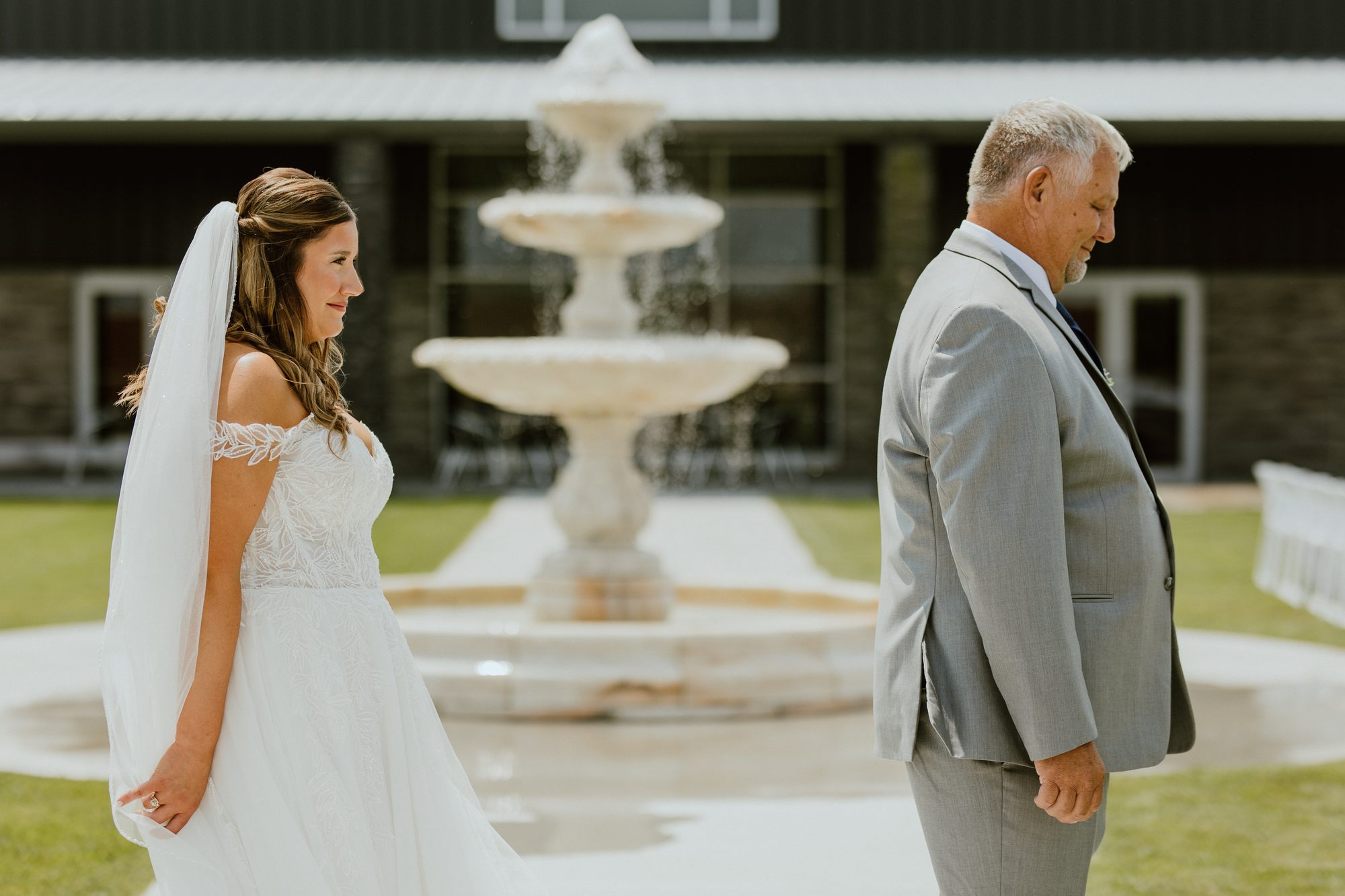 A bride's first look with her father at the courtyard fountain
